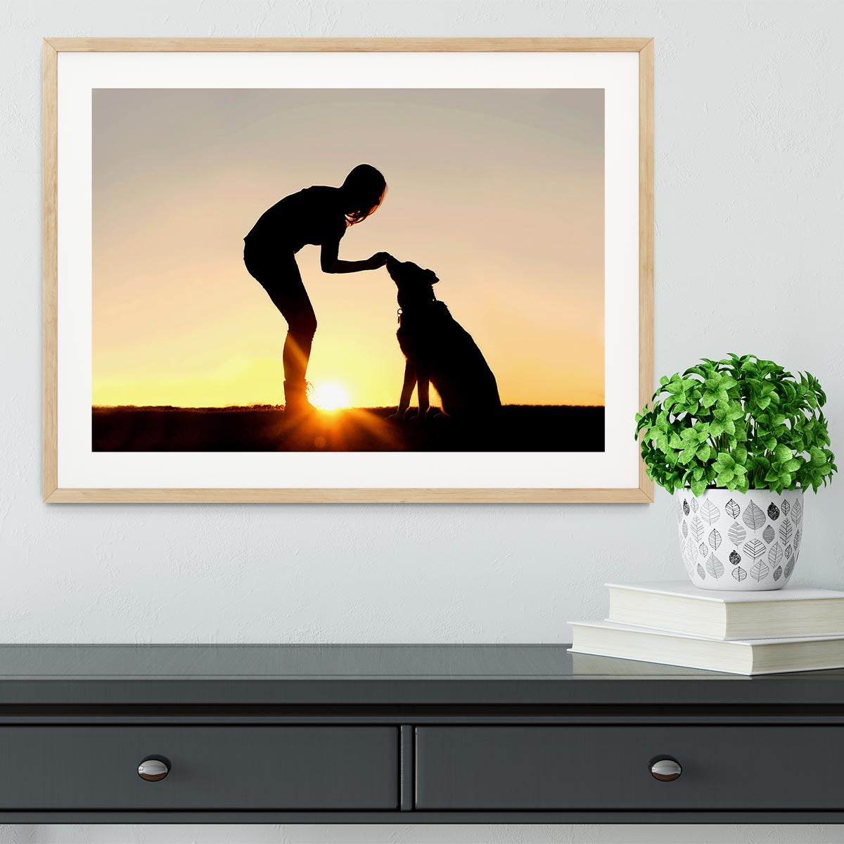 A silhouette of a girl sitting outside in the grass with her pet German Shepherd Mix Dog feeding him treats during training in front of a sunsetting sky. Framed Print - Canvas Art Rocks - 3