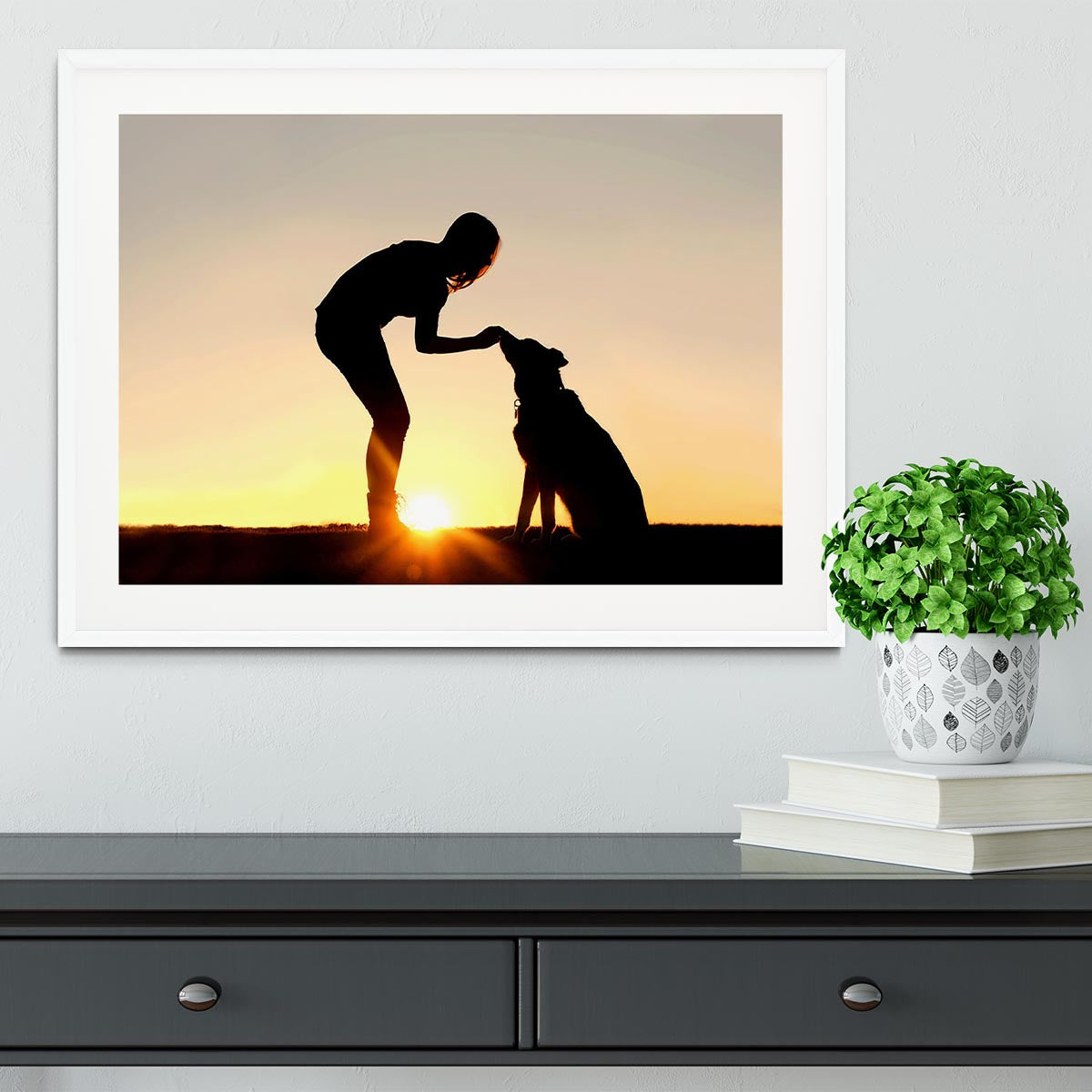 A silhouette of a girl sitting outside in the grass with her pet German Shepherd Mix Dog feeding him treats during training in front of a sunsetting sky. Framed Print - Canvas Art Rocks - 5