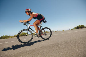Female cyclist on a country road Wall Mural Wallpaper - Canvas Art Rocks - 1