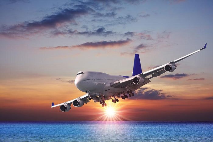 Jet liner over the sea at dusk Wall Mural Wallpaper